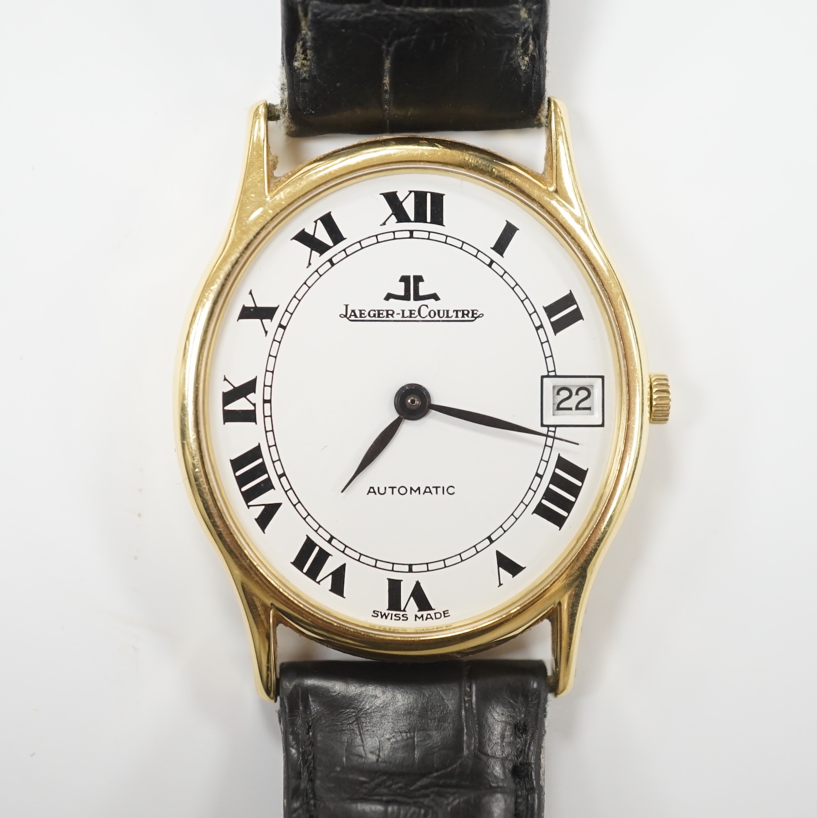 A gentleman's 18k Jaeger LeCoultre automatic dress wrist watch, with oval Roman dial and date aperture, on a leather strap with gold plated Jaeger buckle, case diameter 31mm, no box or papers.